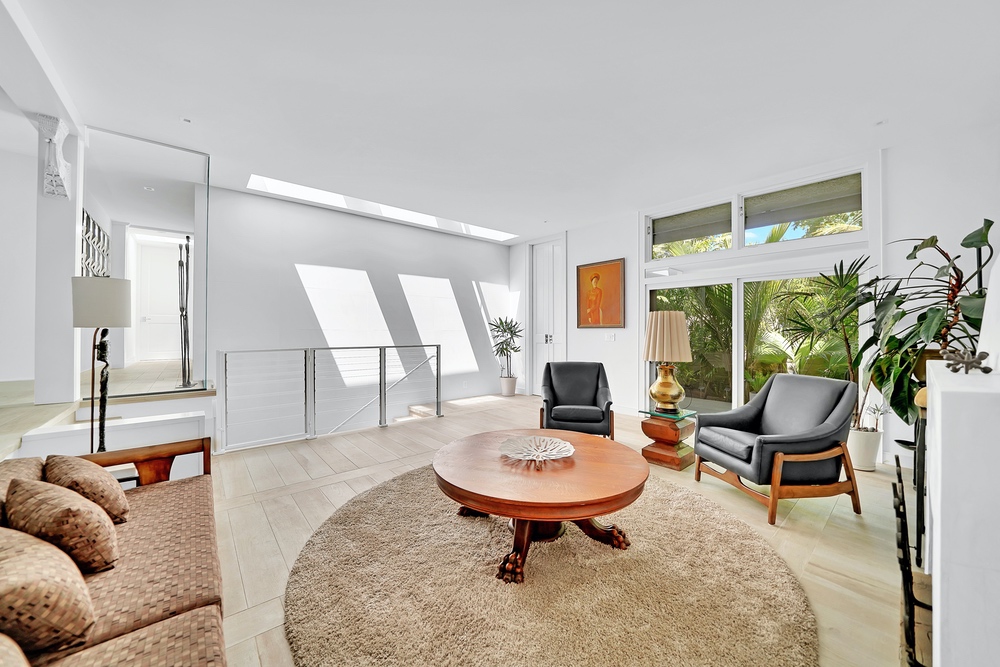 Three skylights bathe the room in natural light and reveal a staircase leading to a bonus room downstairs.