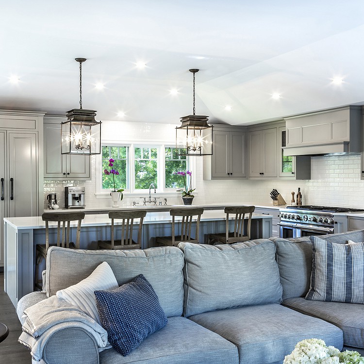 Image of an open-plan living area with a kitchen in the background.