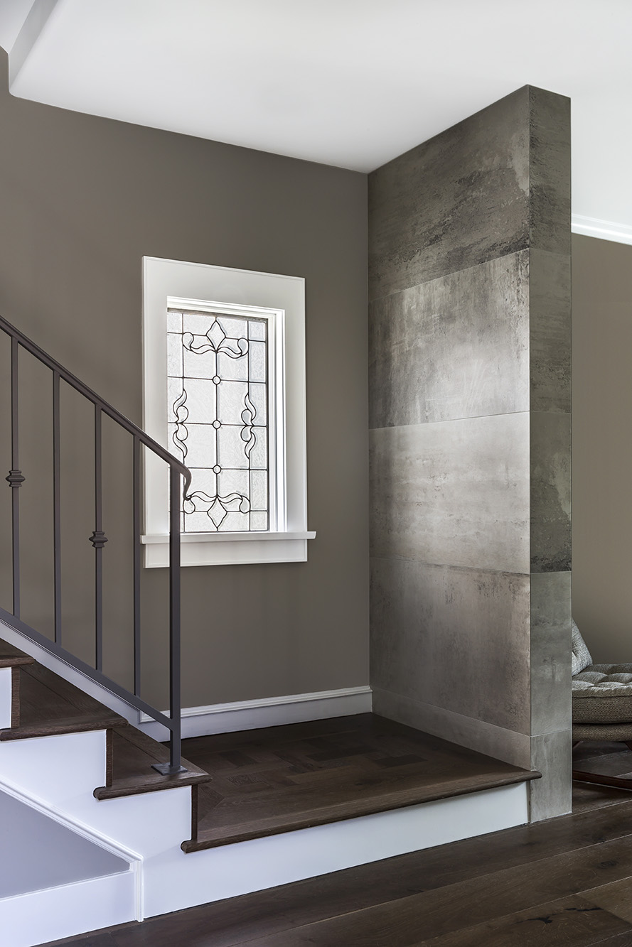 Image of a stairwell with light wood steps and black steel supports, all in a white, light-filled space.