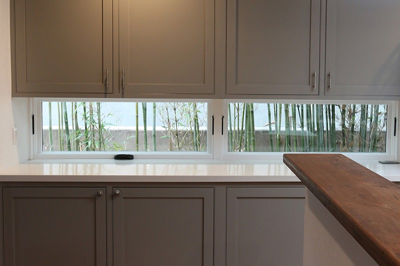 See-through window under kitchen cabinets allows more light to come into the room.